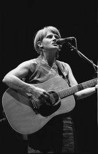 Full length of man playing guitar against black background