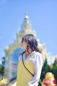 Rear view of woman standing against blue sky