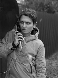 Young man holding telephone on footpath