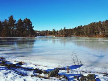 Scenic view of frozen lake against clear blue sky