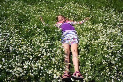 High angle view of teenage girl lying on flowering plants
