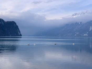 Scenic view of lake by mountains against sky