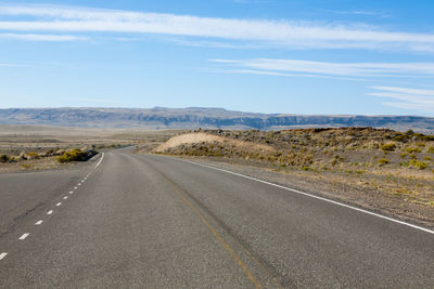 Empty road along countryside landscape