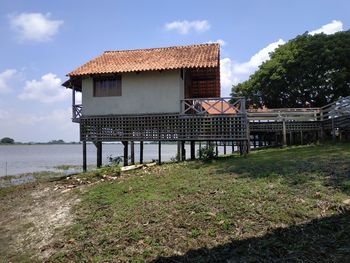 House on field by building against sky