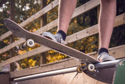 Low section of man skateboarding against railing