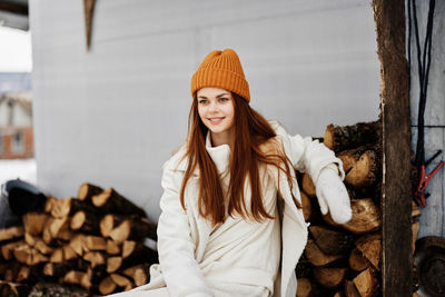 Portrait of young woman standing against wall