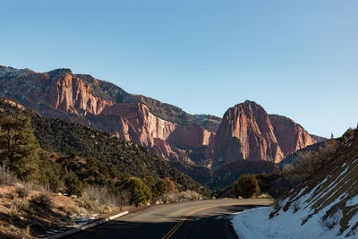 Road by mountain against clear sky