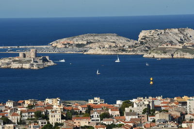 High angle view of townscape by sea against sky