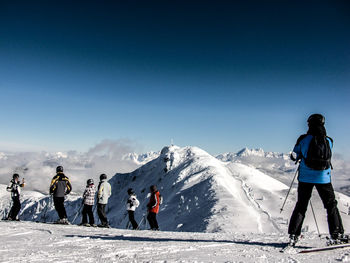 Tourists on snow covered mountain
