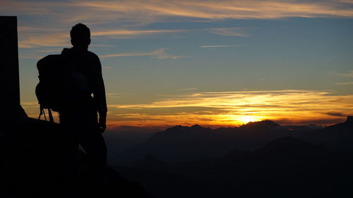 Silhouette of man looking at sunset