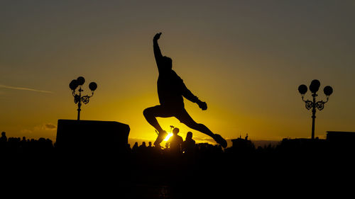 Low angle view of silhouette people against sky during sunset