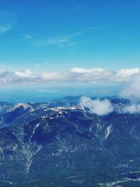 Aerial view of snowcapped mountains against blue sky