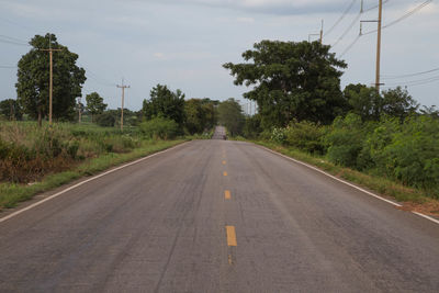 Road amidst trees against sky