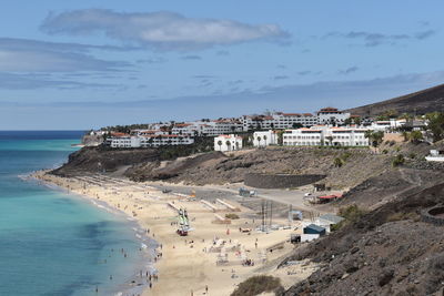 High angle view of townscape by sea against sky