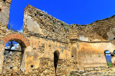 Low angle view of old ruin against blue sky