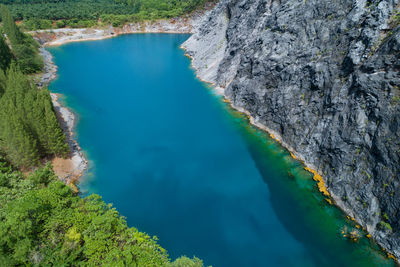 Aerial view of amazing pond in tropical rainforest forest with mountain rocks peak 