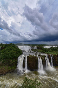 Scenic view of waterfall against sky