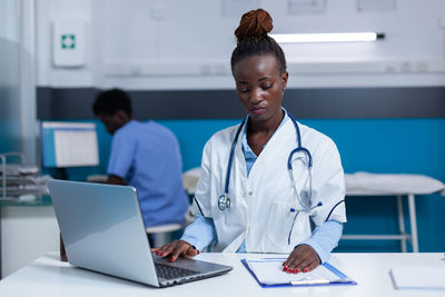 Side view of doctor working at table