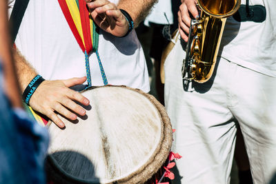 Midsection of people playing saxophone and drum