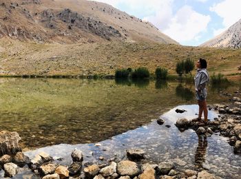 Man standing on rock by lake