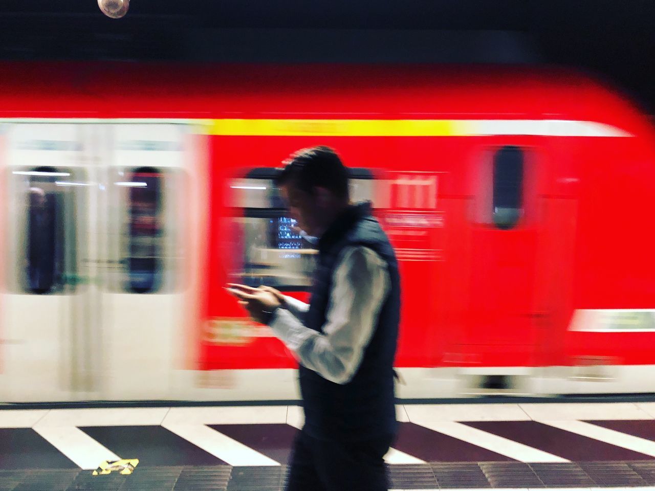 FULL LENGTH OF MAN STANDING AT RAILROAD STATION