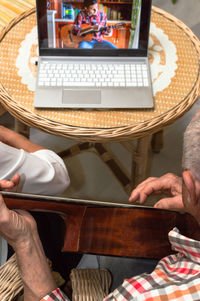 Midsection of man using laptop on table