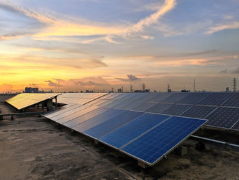 Solar panels install on the roof of office building against sunset sky at dusk. alternative power