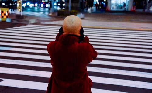 Rear view of a woman crossing road