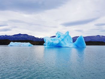 Icebergs in sea against sky