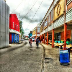 View of city street against cloudy sky