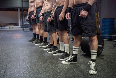 Shirtless athlete wearing sports shoe and shorts standing at gym