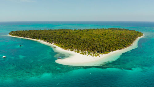 Small island with beautiful beach, palm trees by turquoise water view from above. patongong island 