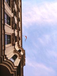 Low angle view of german flag on building against cloudy sky