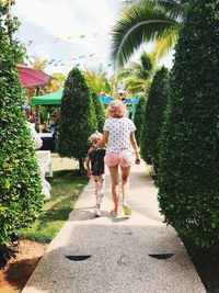Rear view of women walking on footpath