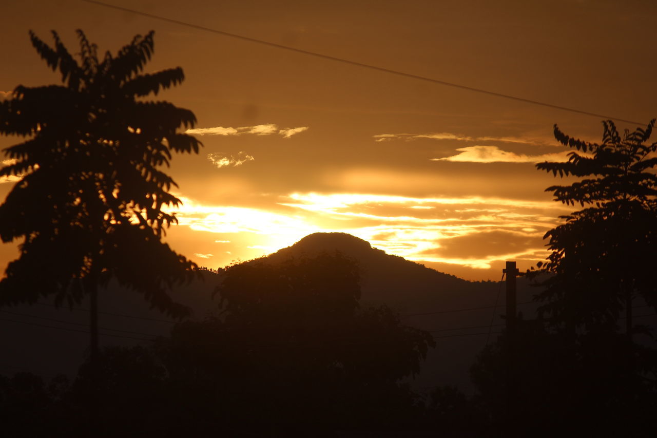 sky, tree, silhouette, sunset, beauty in nature, nature, plant, scenics - nature, mountain, dawn, cloud, tranquility, sun, tranquil scene, sunlight, afterglow, environment, no people, landscape, evening, orange color, idyllic, tropical climate, outdoors, mountain range, palm tree, red sky at morning, land, dramatic sky, darkness