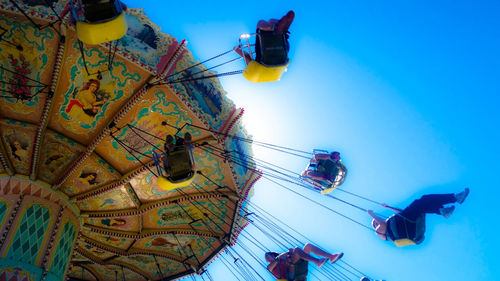 Low angle view of ferris wheel against blue sky