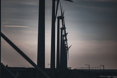 Low angle view of silhouette crane against sky at sunset