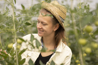 Young woman working as vegetable grower or farmer in the field