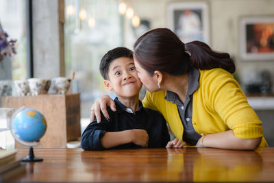 Mother and son sitting at desk