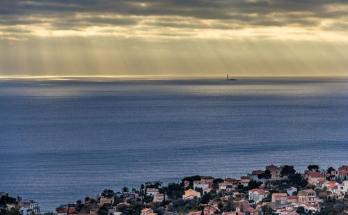 Scenic view of sea by townscape against sky