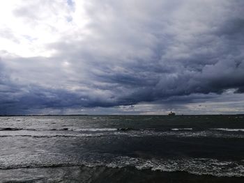 Scenic view of sea against storm clouds