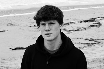 Portrait of young man standing at beach