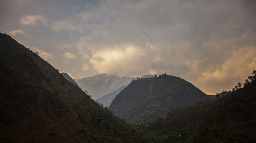 Scenic view of mountains against cloudy sky