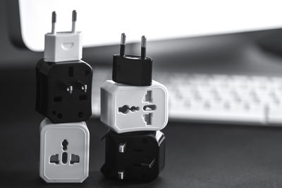 Black and white. multi-purpose plug group on a computer-backed table with keyboard