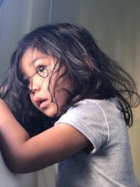 Side view of girl looking away while standing at home