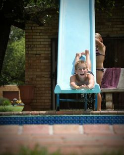Portrait of smiling girl sitting in swimming pool