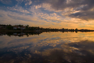 Scenic view of lake against sky at sunset