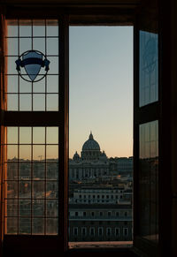 Cathedral against sky seen through window during sunset