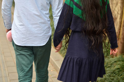 Low section of man and woman walking outdoors