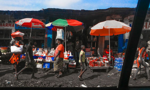 People at market stall during rainy season
